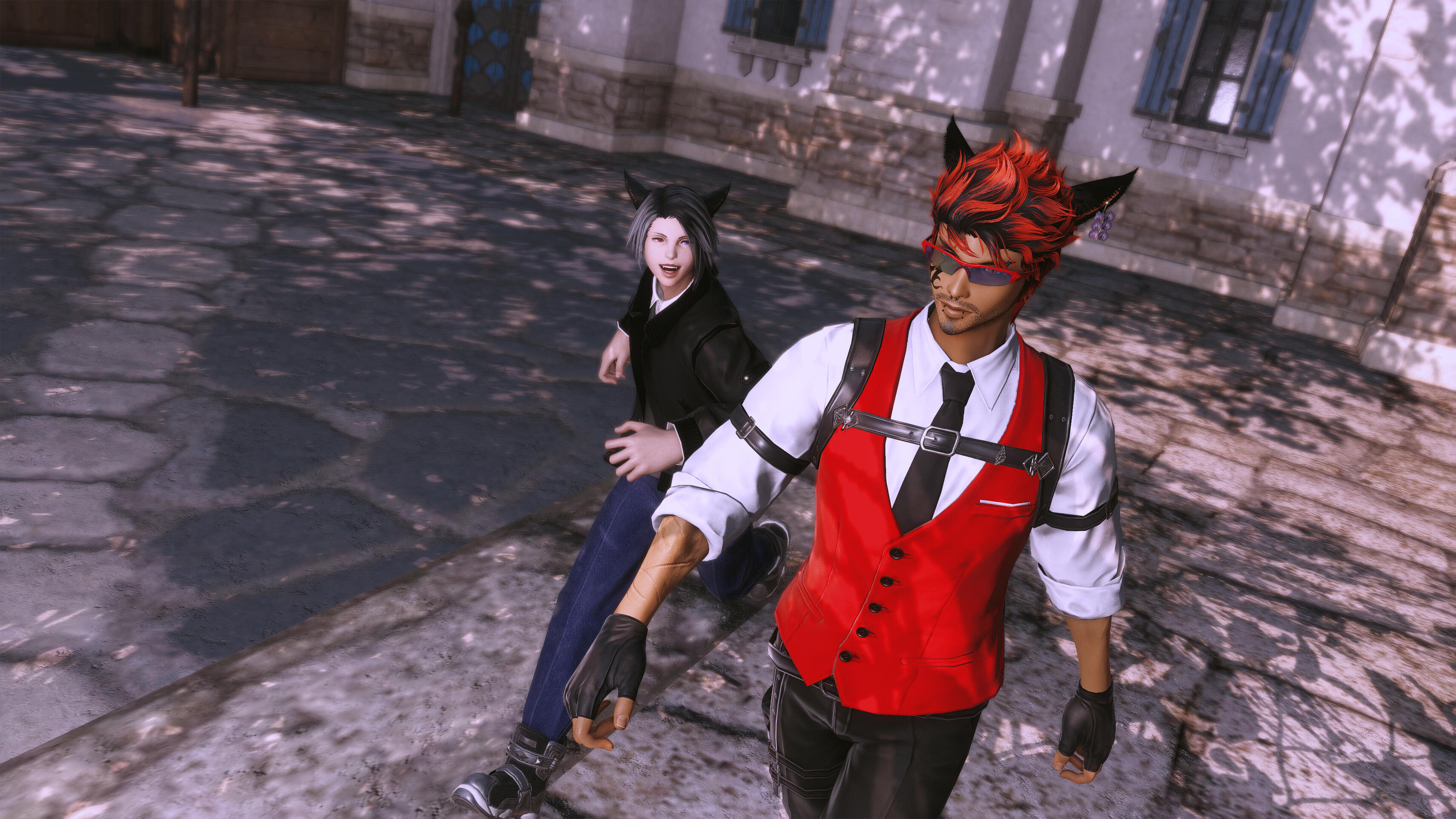 In the foreground, Maxx—with spiky red hair, a red vest, and a futuristic visor—walks forward purposefully. Behind him and slightly to the left, Kell—with black hair and a black jacket—follows smiling. They are on a stone-paved street.